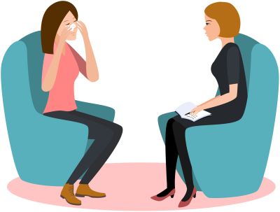Zwei Frauen sitzen sich in Sesseln gegenüber, die eine hält sich die Hand vors Gesicht, die andere macht sich Notizen.